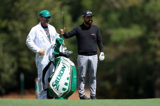 JJ Spaun chats with his caddie at The Masters