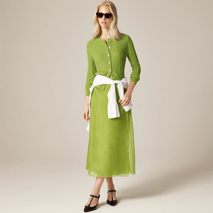 model wears chartreuse skirt and cardigan outfit, model wears plaid trench coat and white top and pants, model wears denim skirts set. 