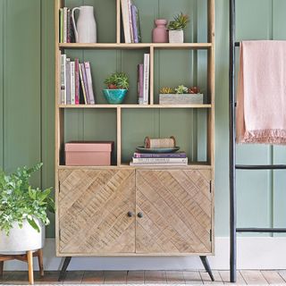 living room storage unit with a towel ladder next to it with a blanket on