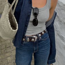 @_jessicaskye wears a pair of Agolde jeans with a studded belt