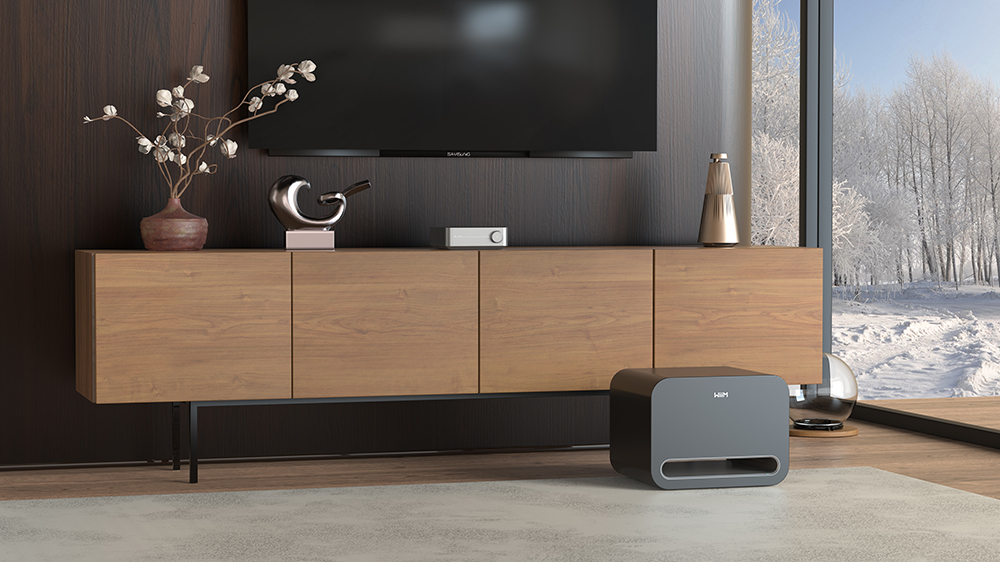 A WiiM Sub Pro on the floor in a living room environment