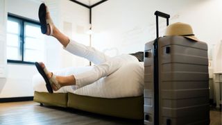 woman's feet and suitcase in hotel room