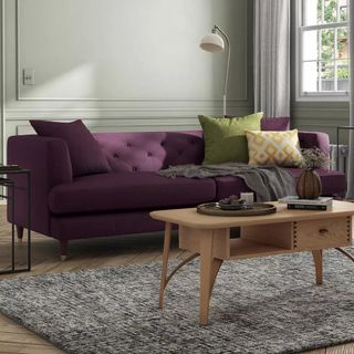 A purple sofa in a neutral living room
