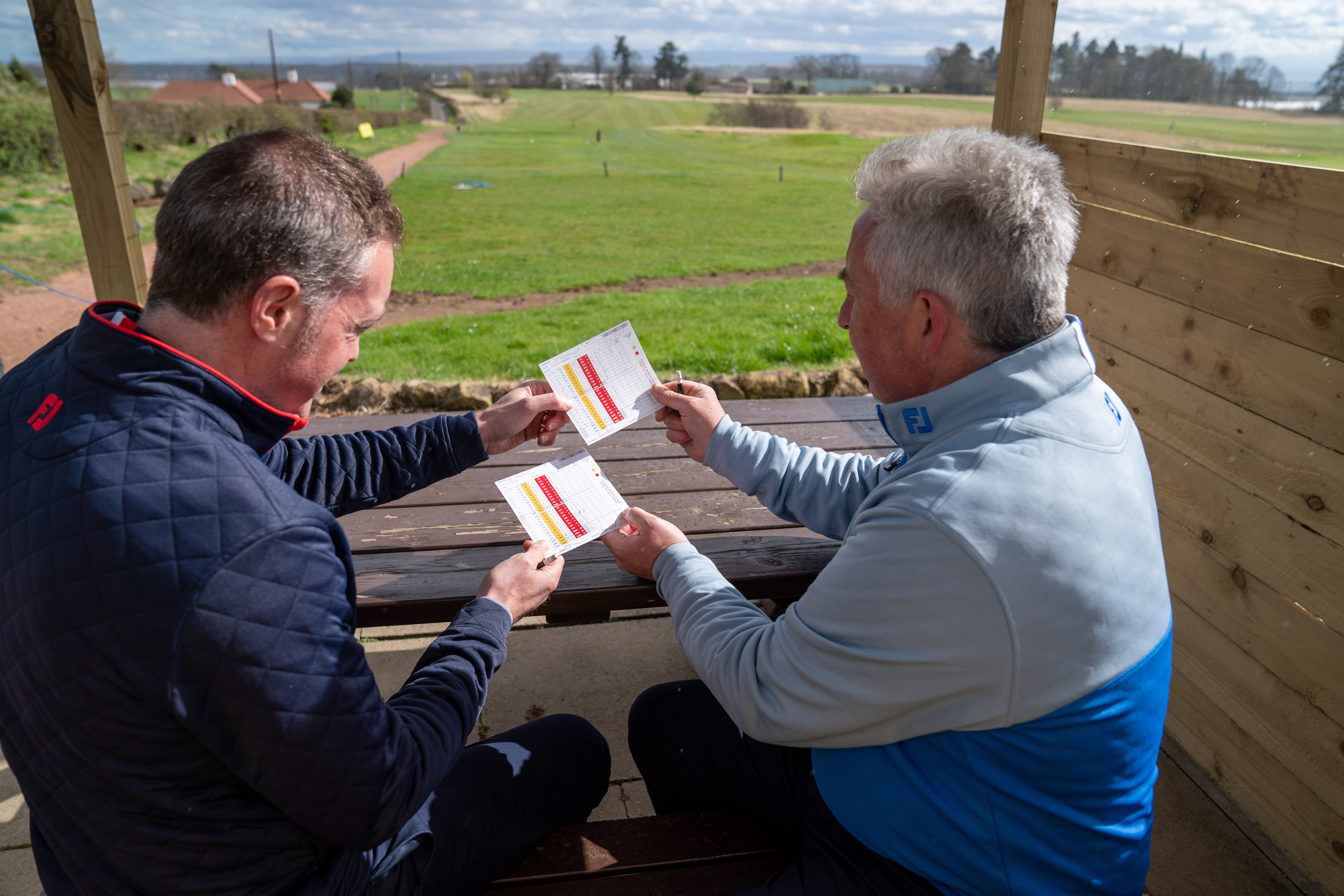 Players exchanging golf scorecards