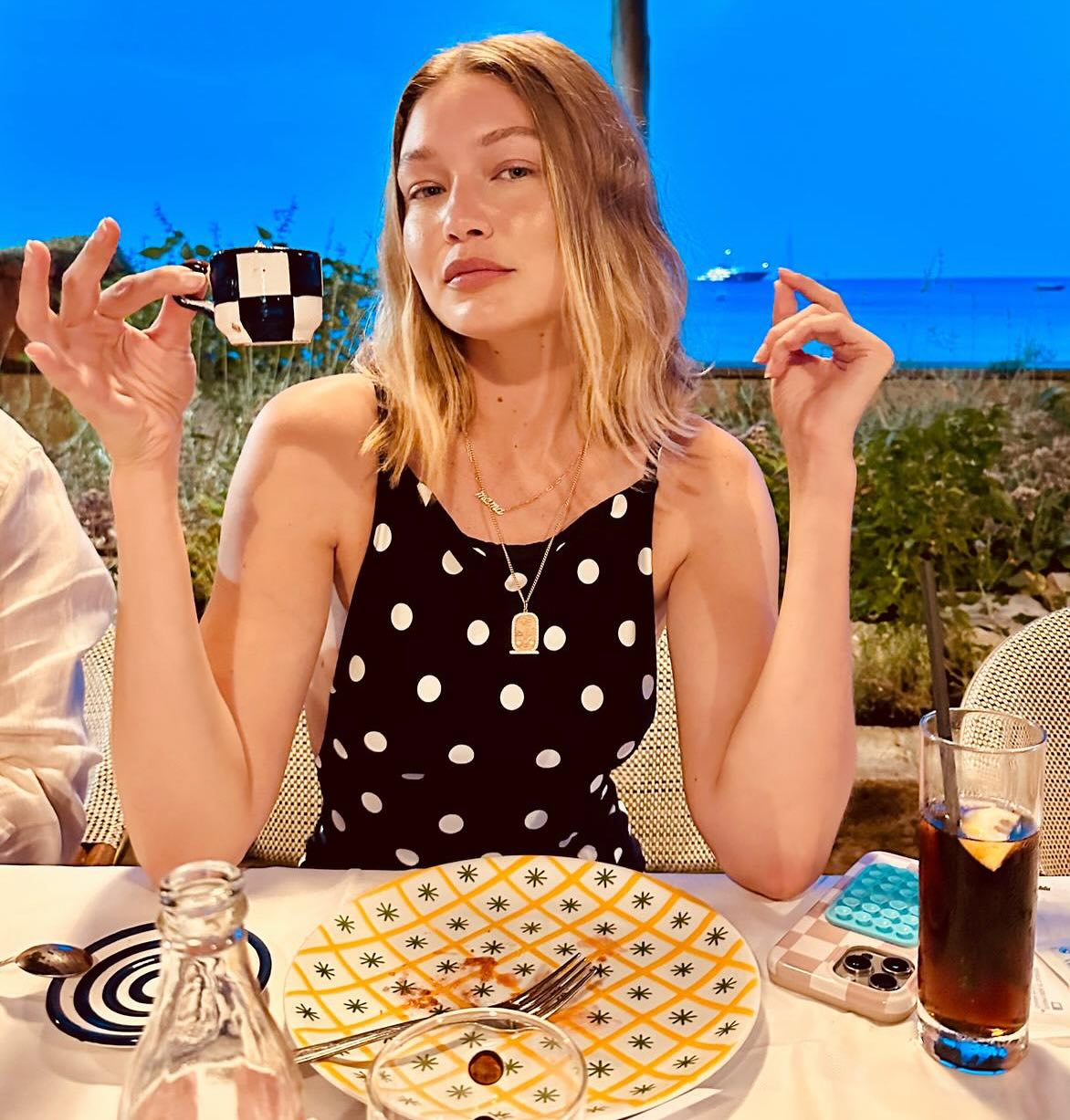 An image of @gigihadid wearing a black and white polka dot top while on holiday in Italy.