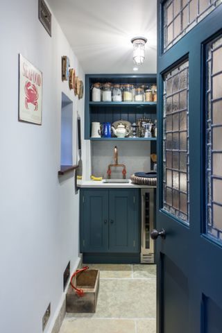 Pantry with sink and cabinets and shelves over