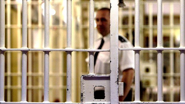 A guard stands behind a locked gate at Pentonville prison