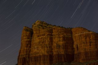 A 20-minute time exposure shows star trails above Courthouse Butte