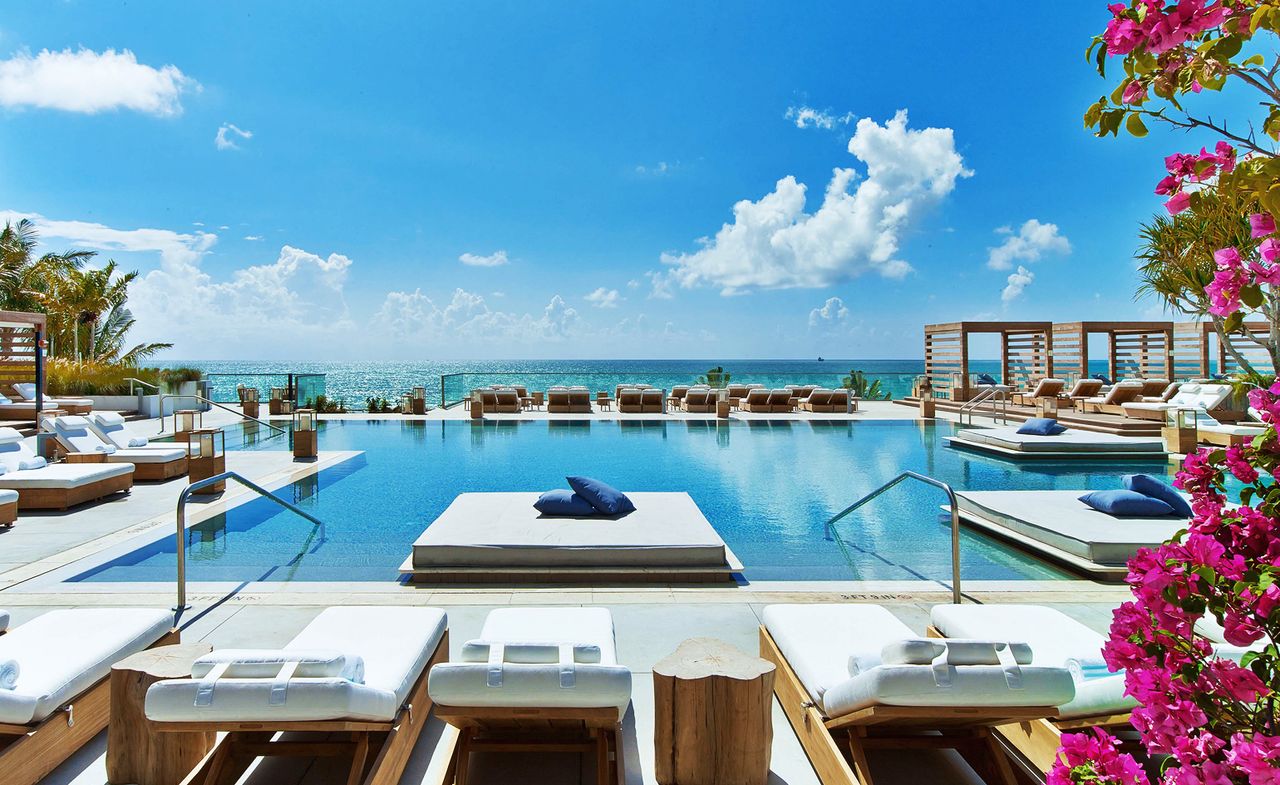 Pool with loungers &amp; day beds overlooking the sea