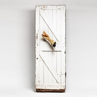 A white door with a hand as the handle