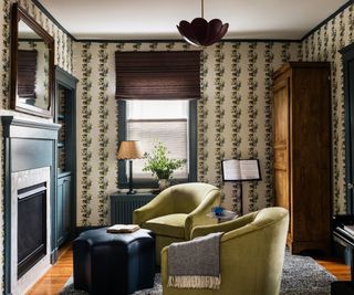 A living room decorated with moody earth tones with an antique wooden armoire in the corner of the room