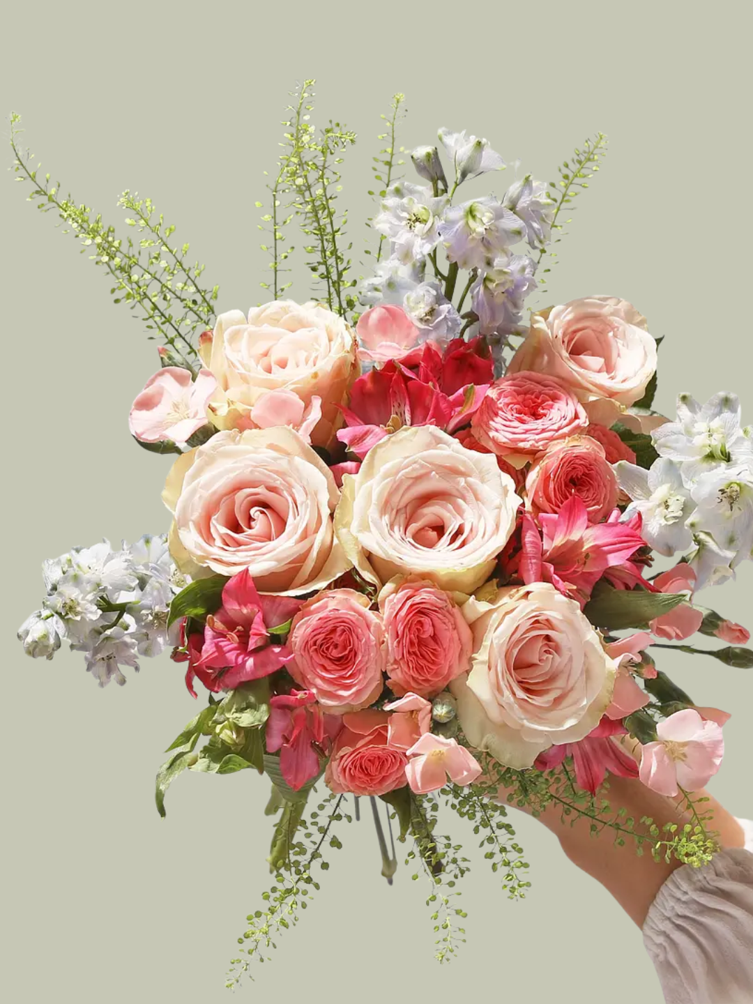 A hand holding a spring bouquet of flowers