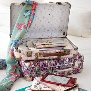 floral suitcase with books and clothes