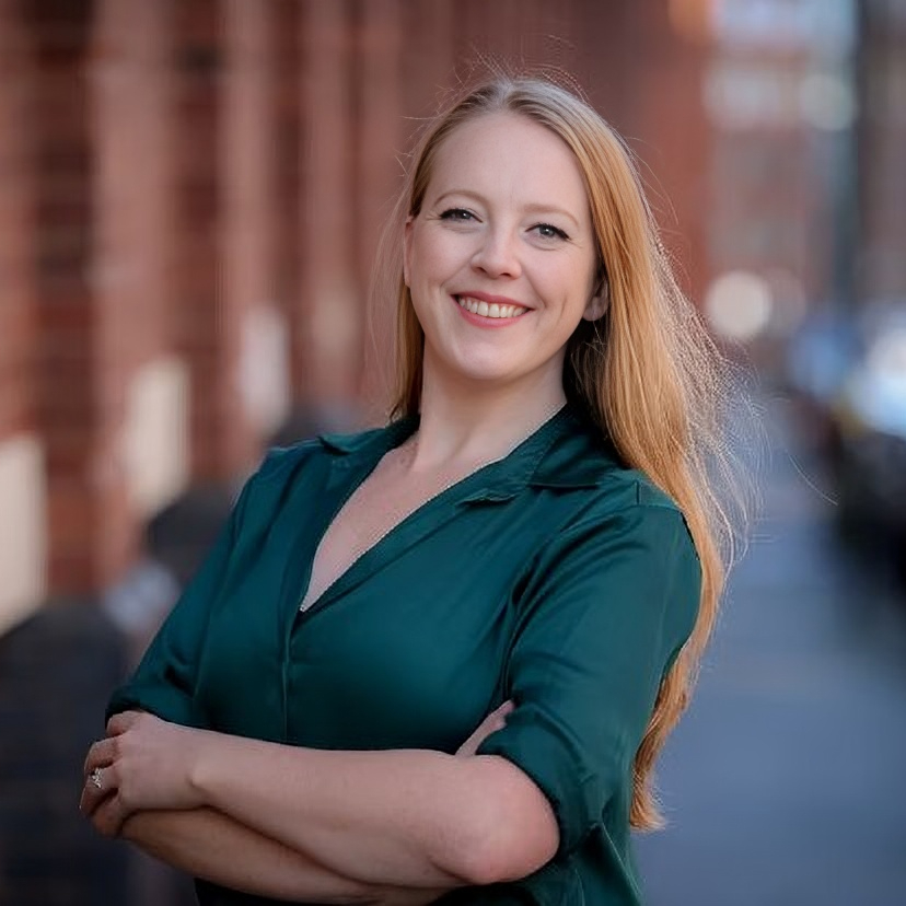 female with green top and long strawberry blonde hair