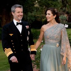 Queen Mary in a mint gown holding hands with King Frederik 