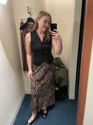 Woman wears black waistcoat and printed leopard skirt