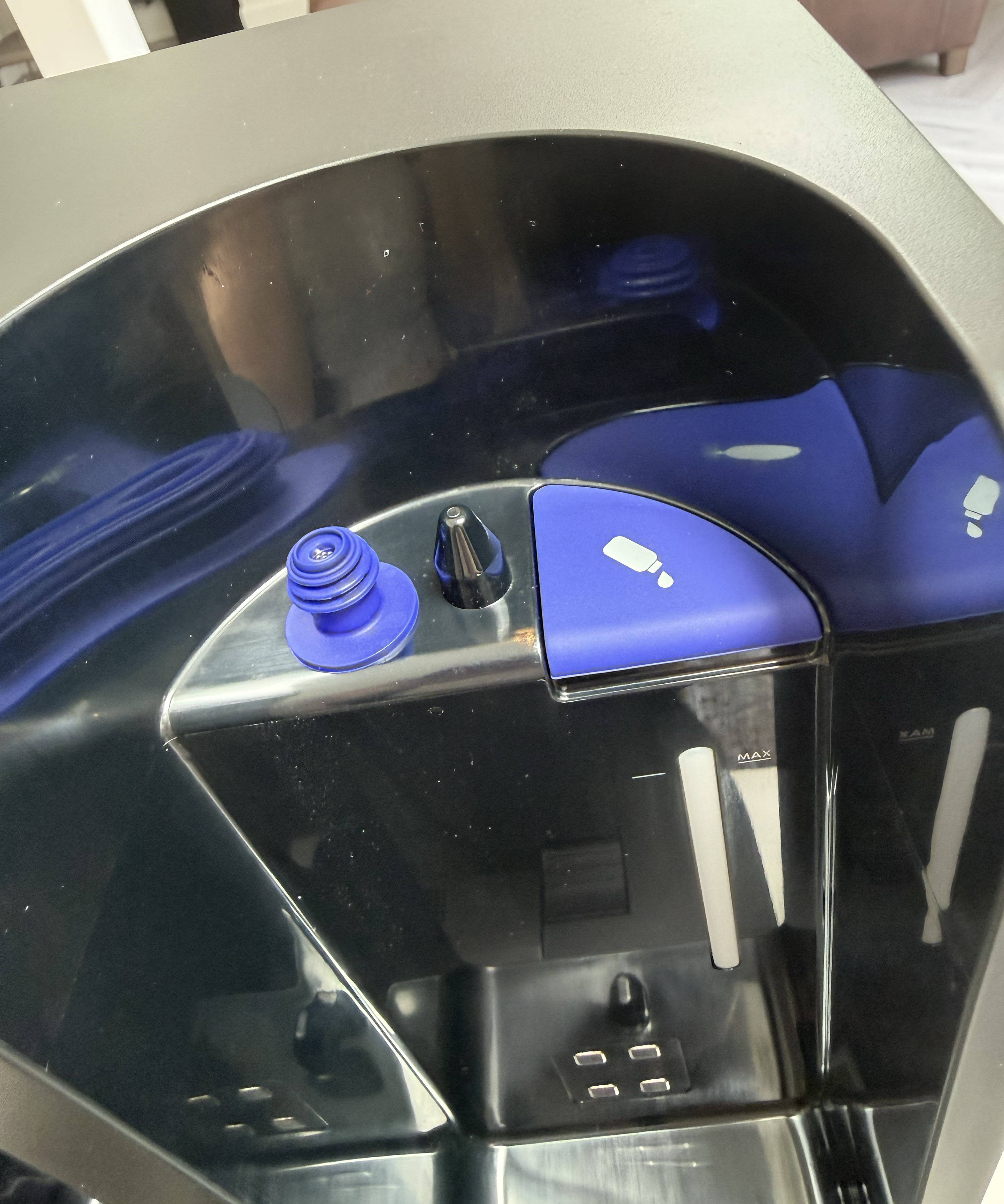 Inside the Dyson Spot+Scrub Ai dock showing water fill points and clean and dirty water compartments