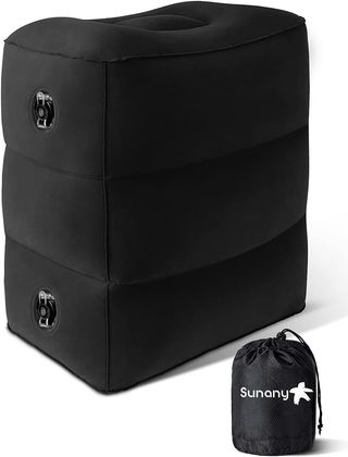 A black Sunany inflatable travel footrest and its small carrying case