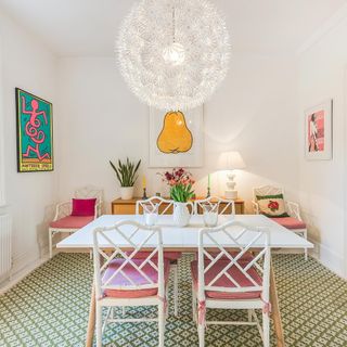 dining area with white wall and artwork and dining table and chairs
