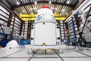 The Space Exploration Technologies, or SpaceX, Dragon spacecraft with solar array fairings attached, stands inside a processing hangar at Cape Canaveral Air Force Station, Fla. The spacecraft will launch on the upcoming SpaceX CRS-2 mission. Image released Jan. 15, 2013.