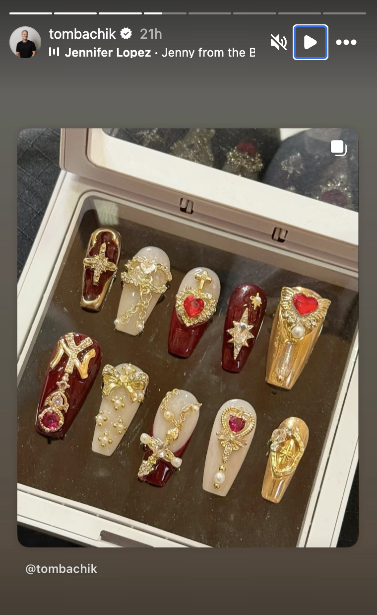 a set of press on nails featuring red and gold charms