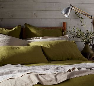 bed with green and beige linen bedding