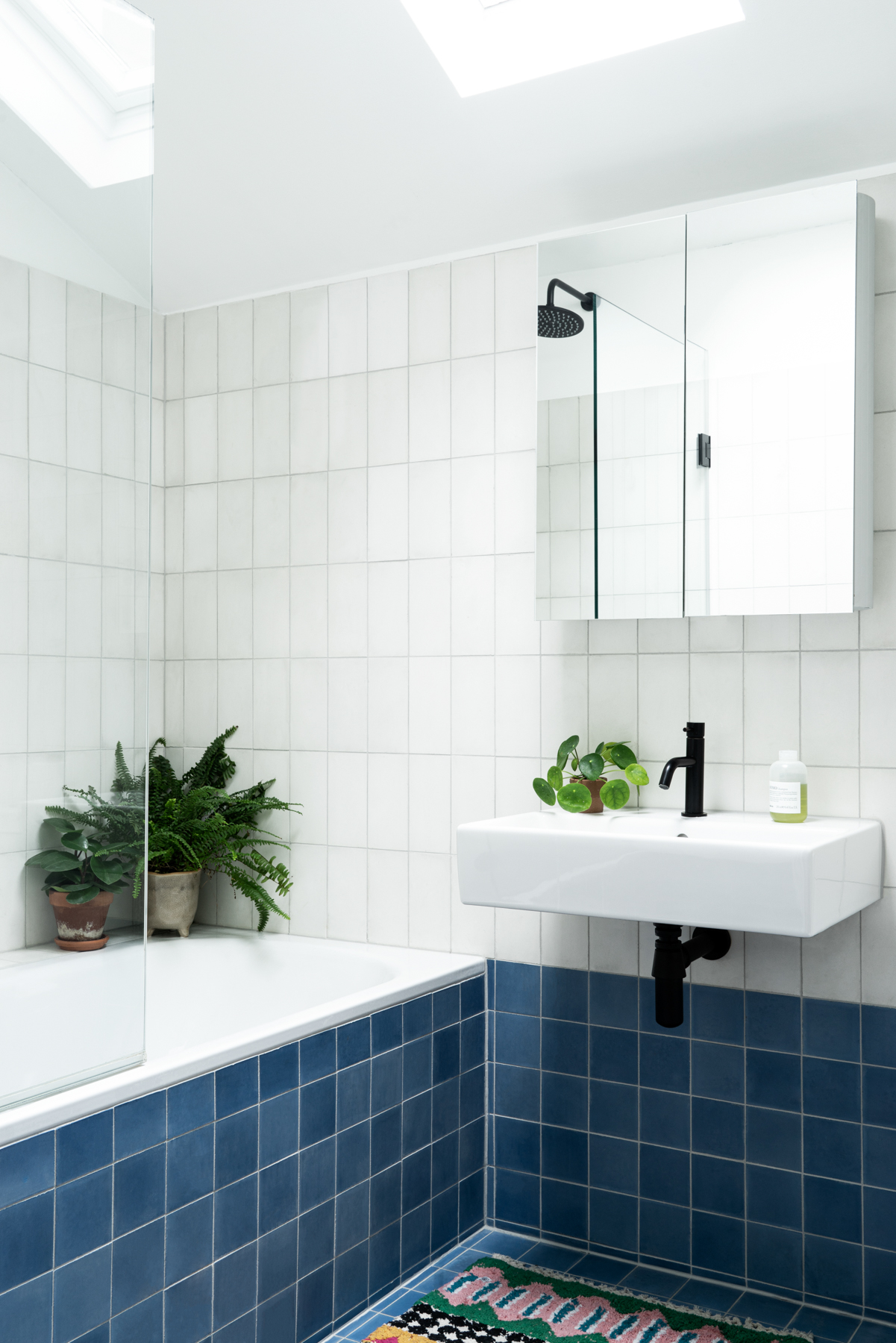 A blue tiles bathroom and white tiles in a shower room