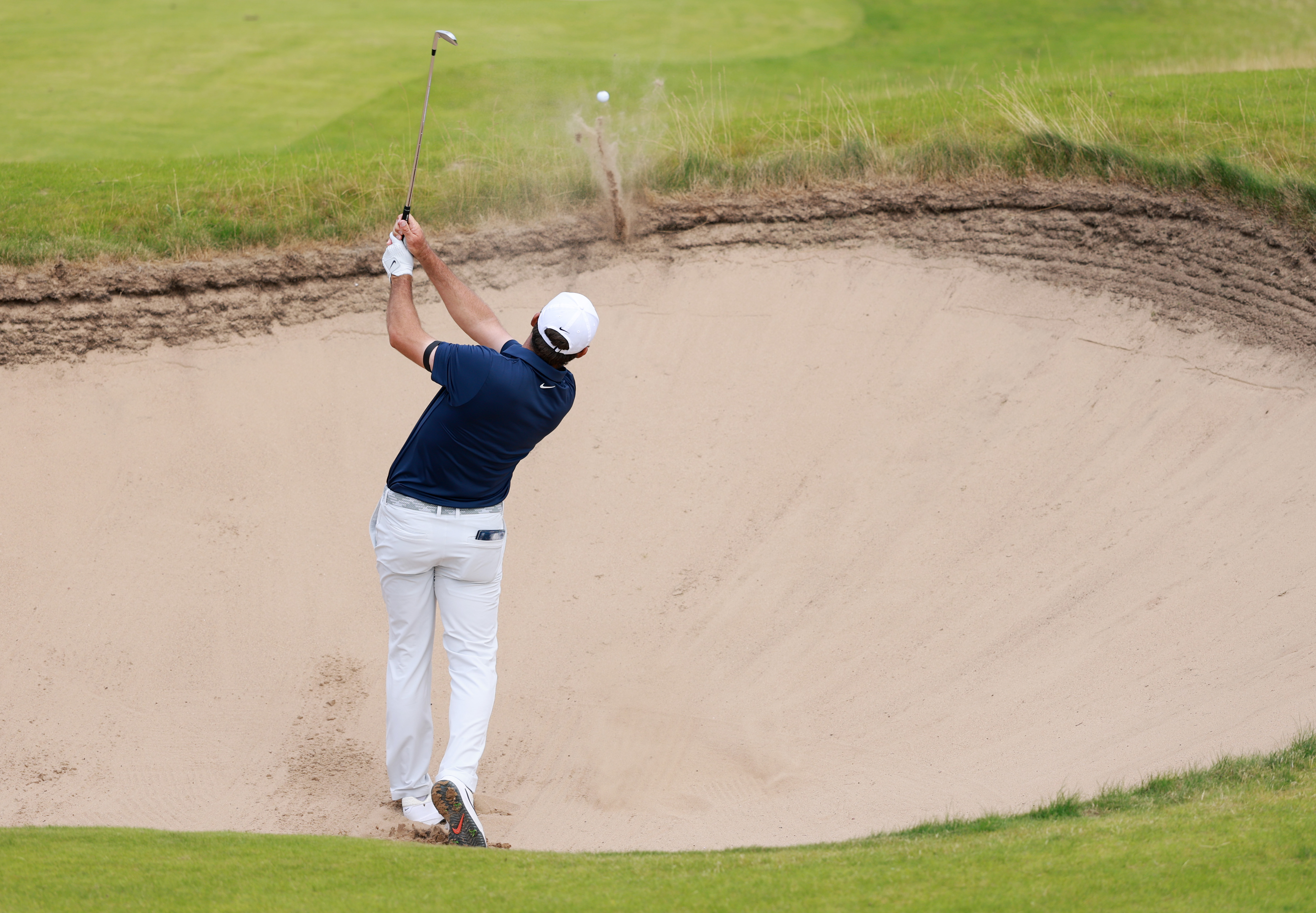Scottie Scheffler hits a fairway bunker shot