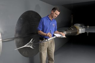 Inside NASA Ames' 9- by 7-Foot Supersonic Wind Tunnel, researcher Don Durston inspects the mounting hardware for the 16-inch scale model of the Boeing concept.