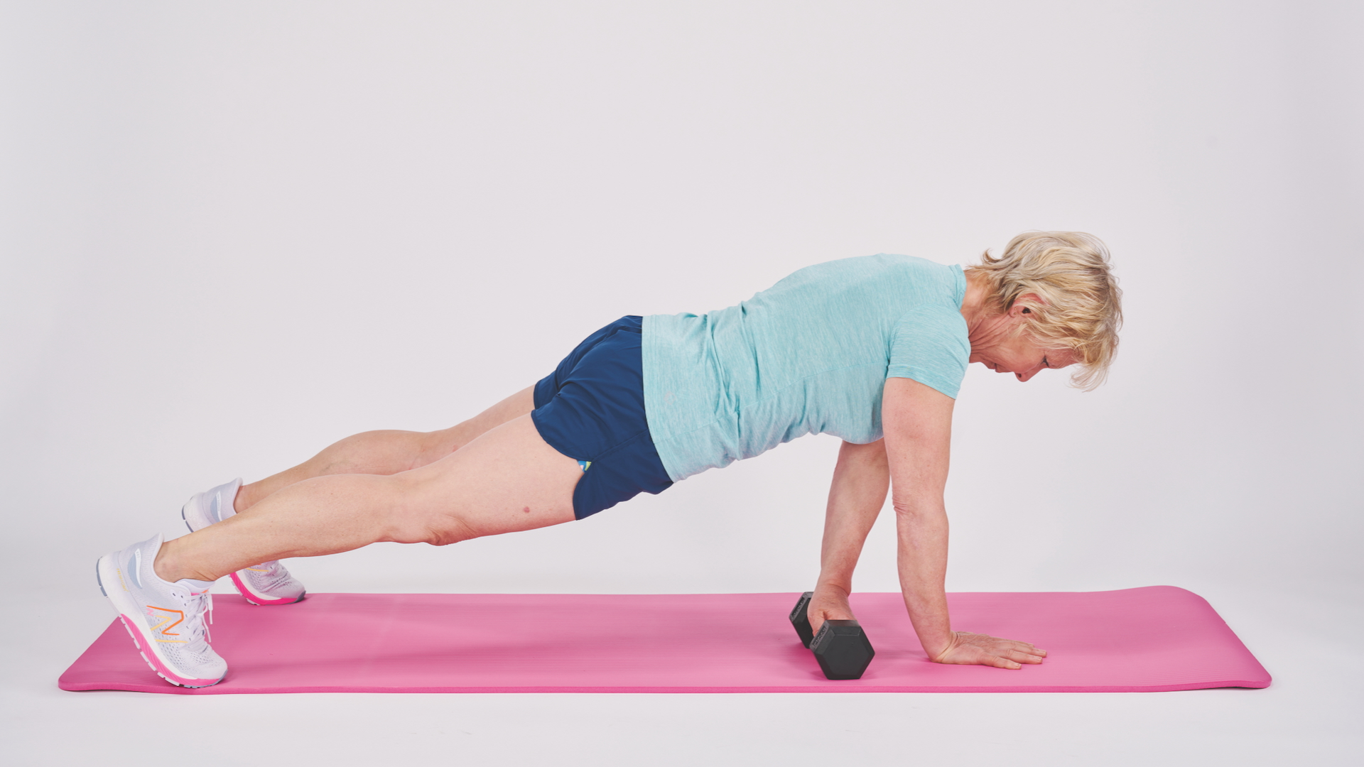 Annie Deadman demonstrating a Plank slide with a dumbbell