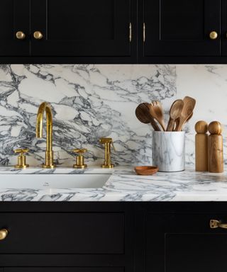 kitchen countertop trends, marble and black kitchen, marble countertop and backsplash, black cabinetry, wood accessories, brass taps
