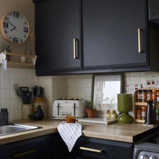 dark kitchen units with worktop wrapped in vinyl and kitchen accessories