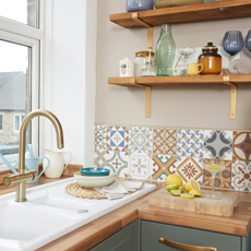 lemons and margarita on a chopping board in frontof a portugese style tiled kitchen wall.