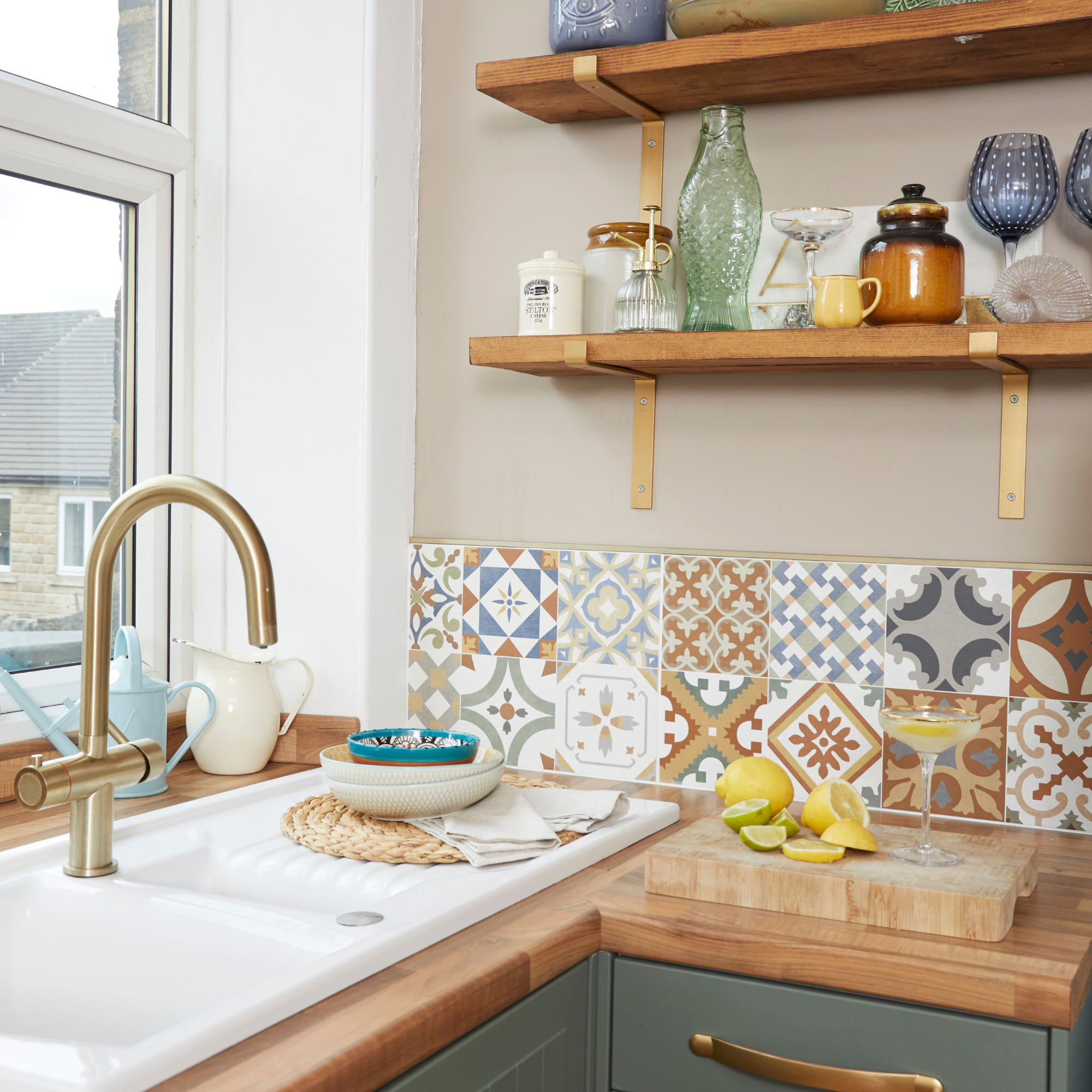 lemons and margarita on a chopping board in frontof a portugese style tiled kitchen wall.