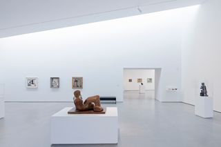 The Hepworth Gallery all-white interior, with paintings hung on the walls and sculptures on the floor.