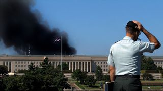washington, dc september 11 a pentagon official stands across the pentagon from which smoke is billowing following an airplane crash 11 september, 2001 more than 30 people were reportedly injured in the terrorist attack and washington dc has been declared in a state of emergency photo credit should read olivier doulieryafp via getty images