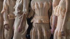 Close up of four women backstage at Issey Miyake by Satoshi Kondo in sculptural pleated dresses