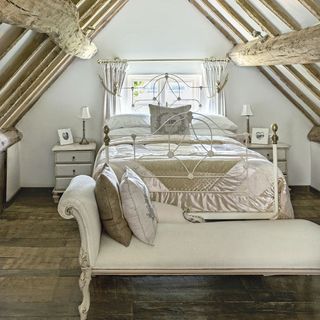 guest bedroom with wooden flooring and bed with pillows