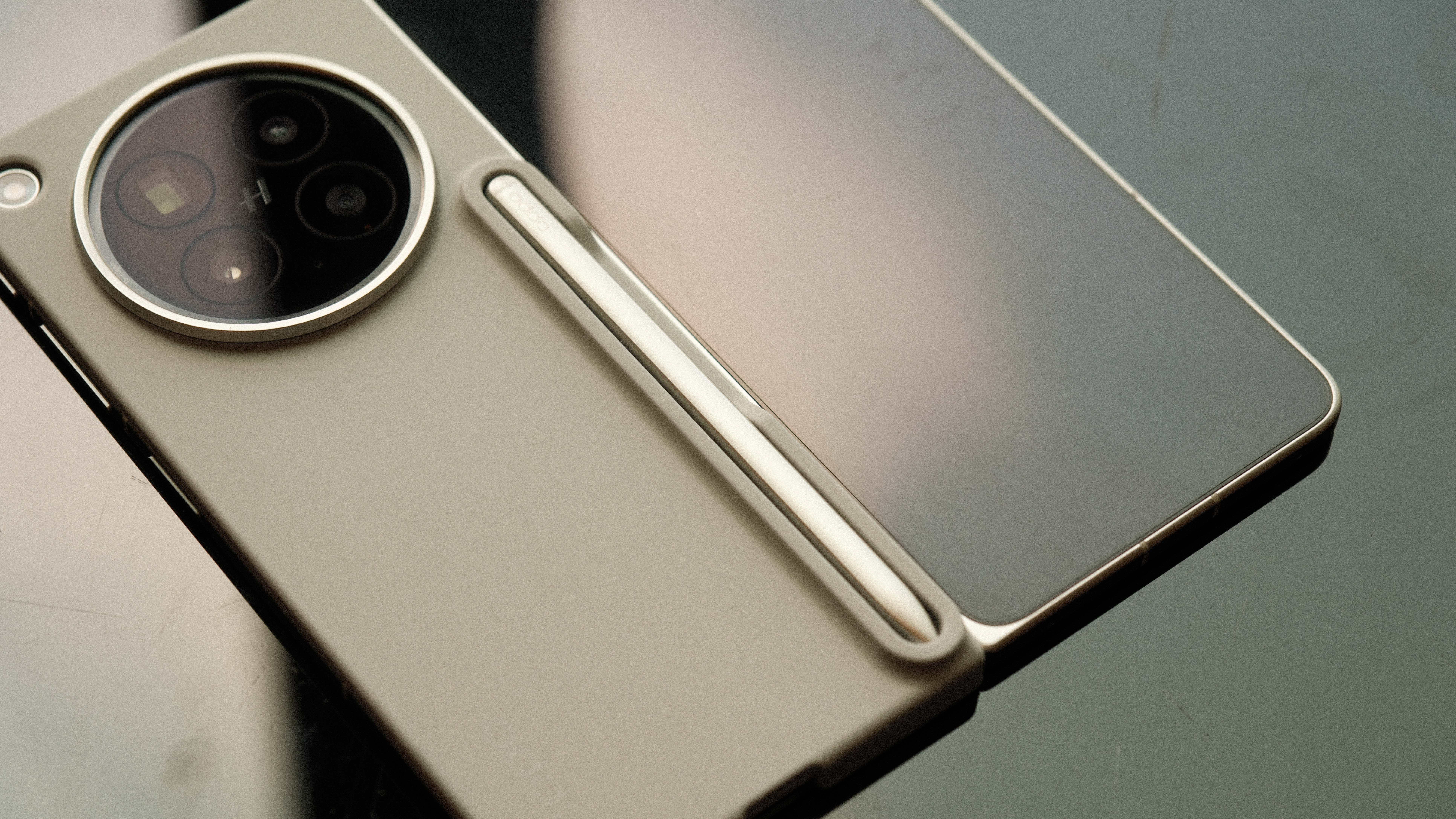 A close-up of the phone in a protective tan case that features a dedicated built-in slot for a stylus. A sleek, silver stylus is seen tucked into the holster on the back of the case.