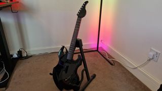 PDP Riffmaster preview image of the guitar on a stand in front of an RGB corner lamp
