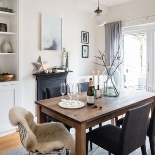 white dining room with wooden table and black fireplace
