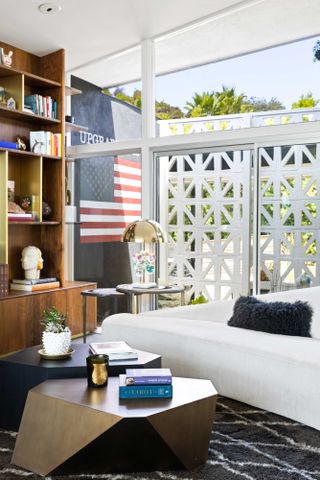 a boucle sofa and walnut shelving unit, with a us flag in the background