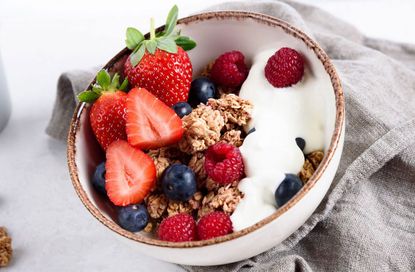 Granola recipe served in a bowl with yoghurt and berries.
