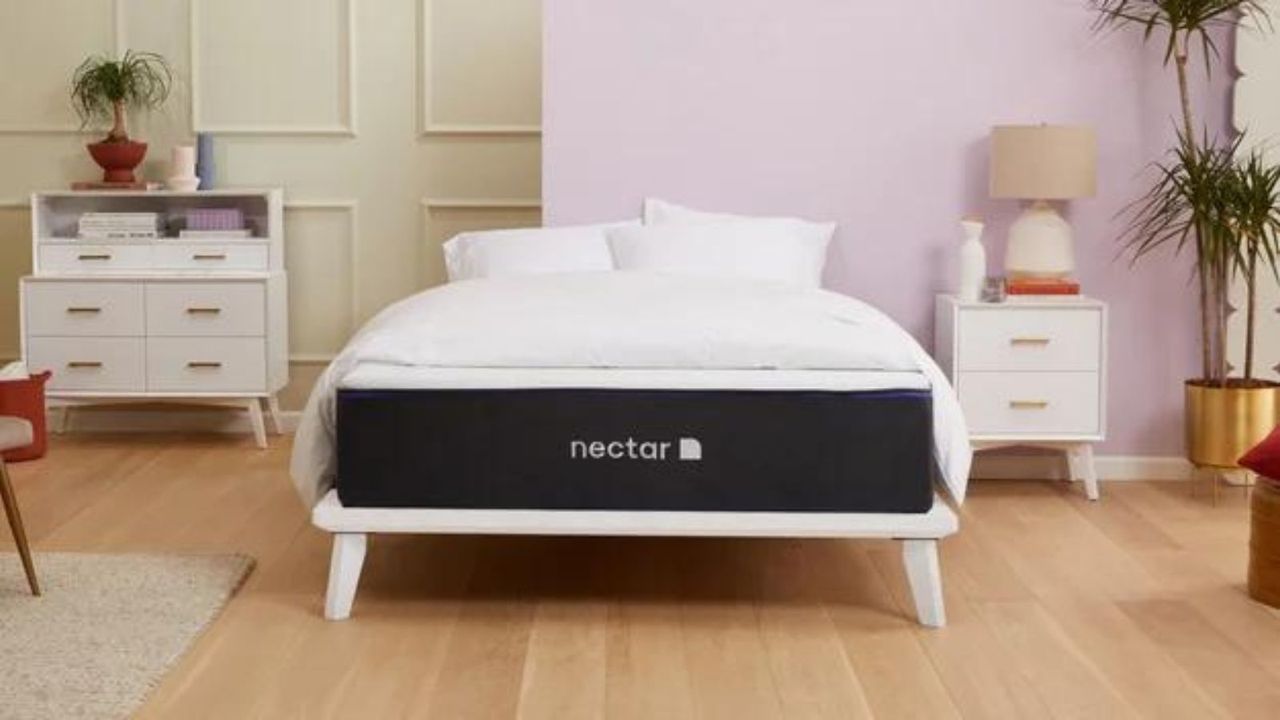 The Nectar Premier Hybrid Mattress against a wall, painted pink and sage green.