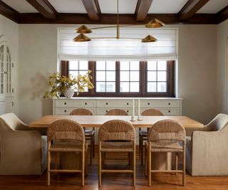 neutral dining room with rattan dining chairs and brass light fitting