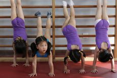 Girls do handstands during gymnastics lessons at the Shanghai Yangpu Youth Amateur Athletic School in Shanghai, China.