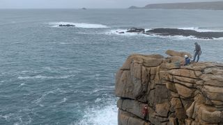 how to start sea cliff climbing: climbers at the top of a cliff