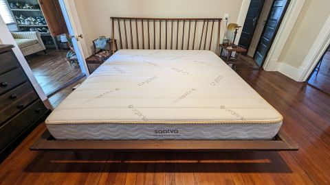 Saatva memory foam hybrid mattress on a bed frame in tester's bedroom