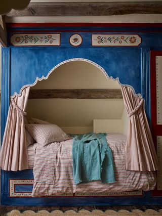 A built-in bed with a canopy and curtains