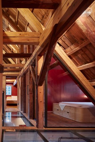 Explosed wooden beam structure around bedroom in eaves of a cabin